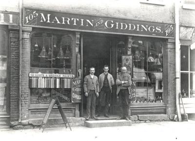 Martin & Giddings Druggist 3 men in front 105 W. Main St. Cigars Paints Restaurant